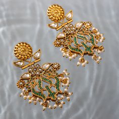 Introducing our stunning drop earrings, a perfect fusion of contemporary and traditional design. These earrings are crafted using a beautiful blend of CZ stones, polkis, and traditional temple craft. The bold design of these earrings starts with the temple work in the studs. The polkis are set on floral motifs followed by the inverted lotus motif which is encrusted with black CZ stones. Crafted in silver and then gold-plated, these earrings are not only gorgeous but also durable. Temple Craft, Temple Work, Lotus Motif, India Inspired, Lotus Earrings, The Temple, Floral Motifs, Cz Stone, Traditional Design