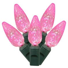 pink led christmas lights on black wire with green tips and clear bulbs, isolated against a white background