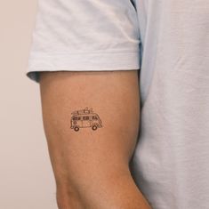 a man's arm with a small tattoo of a camper van on it