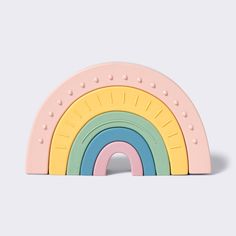 a wooden toy with a rainbow design on the front and sides, set against a white background