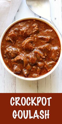 crockpot goulash in a white bowl with spoon on the side