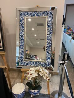 a blue and white mirror sitting on top of a table next to a potted plant