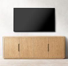 a flat screen tv mounted to the side of a wooden cabinet in an empty room