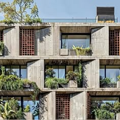 an apartment building with plants growing on the balconies