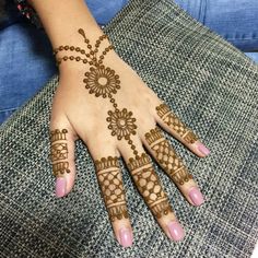 a woman's hand with henna tattoos on it