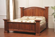 a wooden bed frame sitting on top of a hard wood floor next to a potted plant