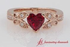 a red heart shaped diamond ring with leaves on the band and side stones in white gold