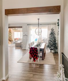 the dining room is decorated for christmas with white and red decorations on the table, along with other holiday decor