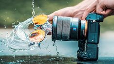 a person is holding a camera and splashing water