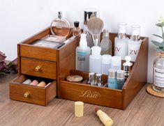 an assortment of cosmetics and personal care items in a wooden box on a table next to flowers