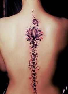 a woman's back tattoo with flowers and vines