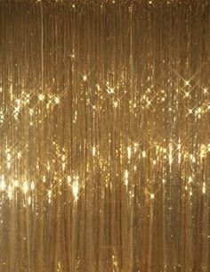 gold sequin curtain with stars and sparkles on the top, in front of a black background