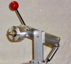 a metal object with a red ball on it's head and two screws