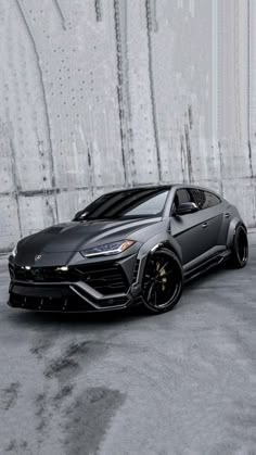 a black sports car parked in front of a wall