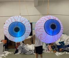 two large blue eyes hanging from strings in a room