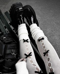 two pairs of legs with black and white stockings on top of them, tied to luggage