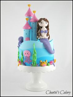 there is a cake decorated with an image of a mermaid and octopus on the top