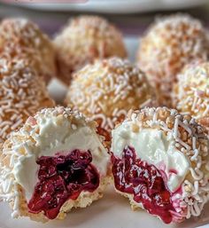 there are many desserts on the plate with white frosting and cranberry filling