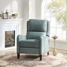 a living room with a fireplace and a blue recliner chair in front of a window