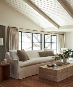 a living room with white couches and large windows in it's center area