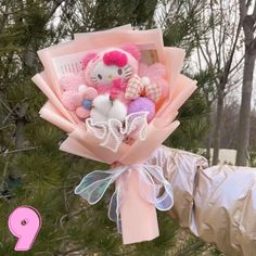 a hello kitty bouquet in the shape of a teddy bear with other stuffed animals on it