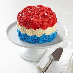 a red, white and blue cake on a plate with a knife next to it