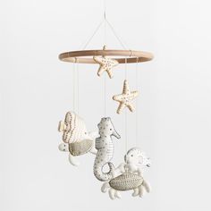 three sea animals hanging from a wooden mobile