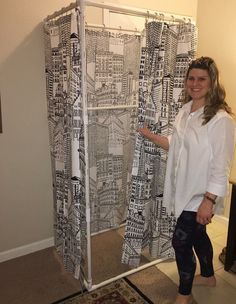 a woman standing in front of a shower curtain with black and white designs on it