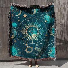 a blanket with an image of the sun and moon on it, hanging from a wall