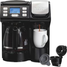 a coffee maker with two cups next to it