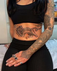 a woman with tattoos on her stomach and arm