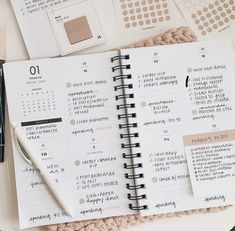 an open planner book sitting on top of a table next to a pen and pencil