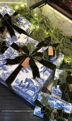 presents wrapped in blue and white paper with black bows are sitting on top of each other