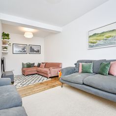 a living room with two couches, a chair and a rug on the floor