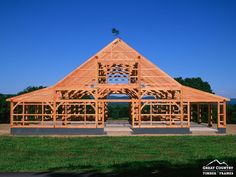 a large wooden structure sitting on top of a lush green field