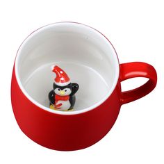 a penguin figurine sitting in a red cup