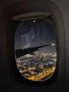 an airplane window looking out at the city lights