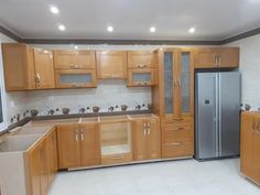 an empty kitchen with wooden cabinets and stainless steel appliances in the middle of the room