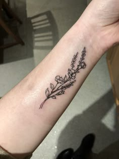 a woman's arm with a flower tattoo on it