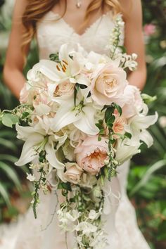 a bride holding a bouquet of white and pink flowers