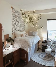 a bedroom with white bedding and string lights on the ceiling, along with a tree in the corner