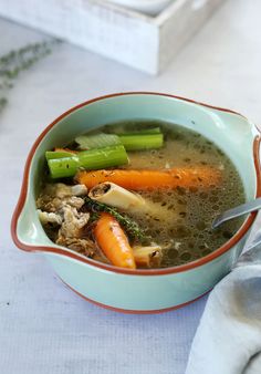 a bowl of soup with carrots, celery and other veggies