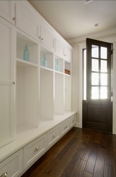 an empty room with white cabinets and wood flooring on the bottom right hand side