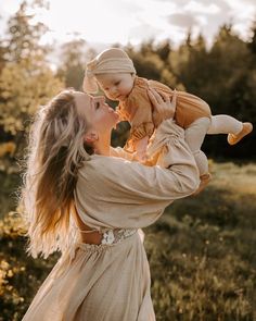 a woman holding a baby up in the air