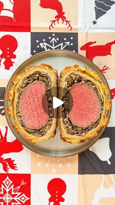 a steak sandwich cut in half on top of a checkered tablecloth with red and black designs