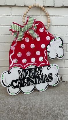 a red and white christmas decoration hanging on the side of a brick wall next to a door