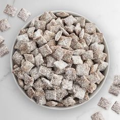 a bowl filled with sugar cubes on top of a white counter next to other pieces of food