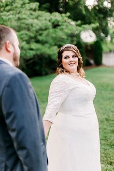 a woman in a white dress standing next to a man