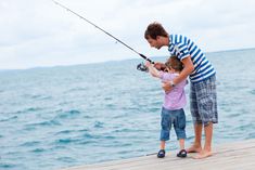 father and son fishing on the pier at the lake stock photo - image 349874