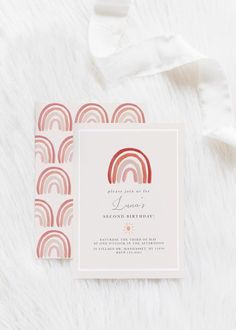 the wedding stationery is laid out on a white furnishing